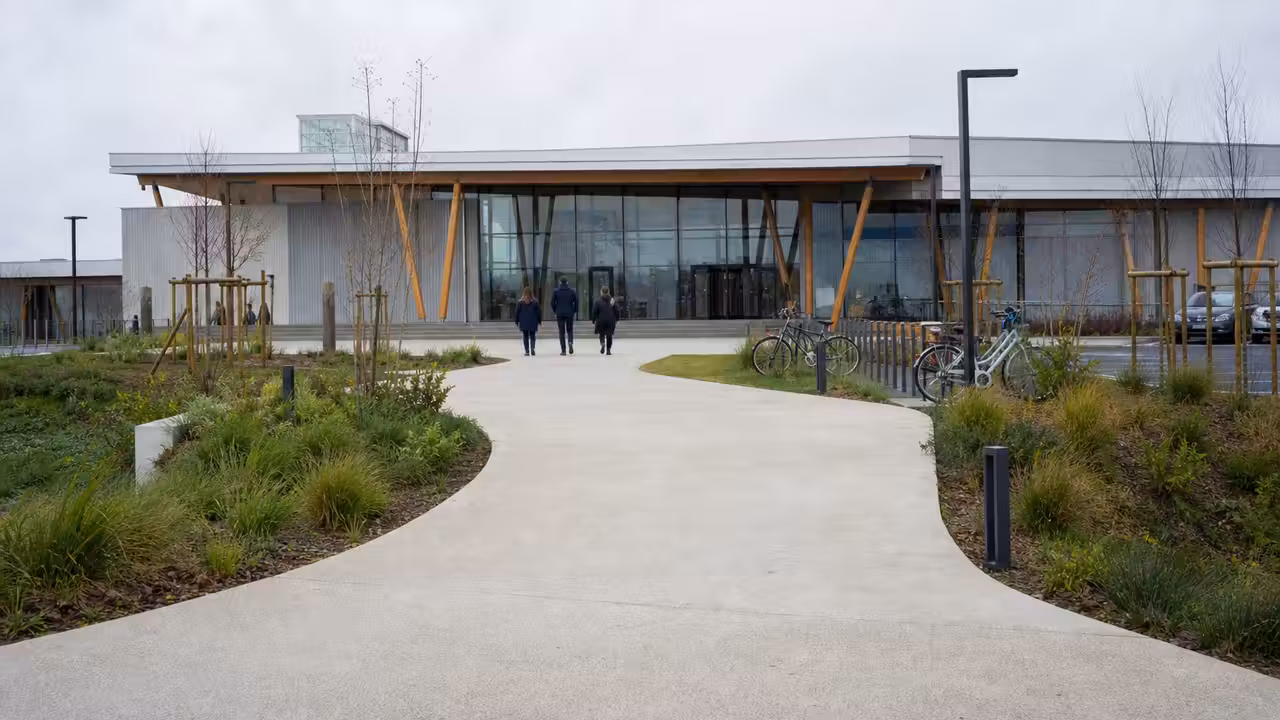 Vue extérieure d’un centre aquatique contemporain avec bassin couvert et parvis accessible aux usagers