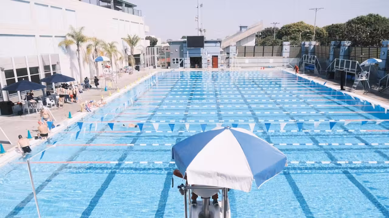 Vue extérieure d’un centre aquatique municipal moderne avec toiture solaire et parvis végétalisé