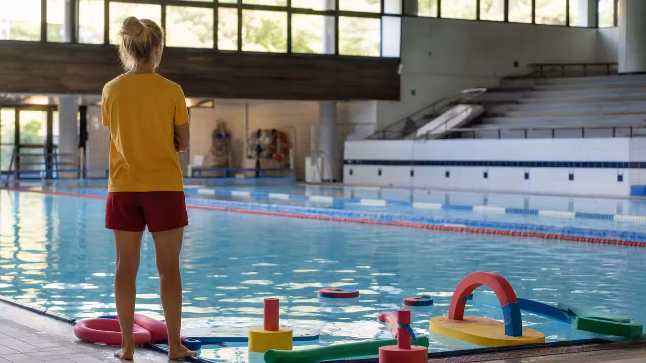 Séance d’éveil aquatique encadrée avec parents et jeunes enfants dans une piscine municipale lumineuse