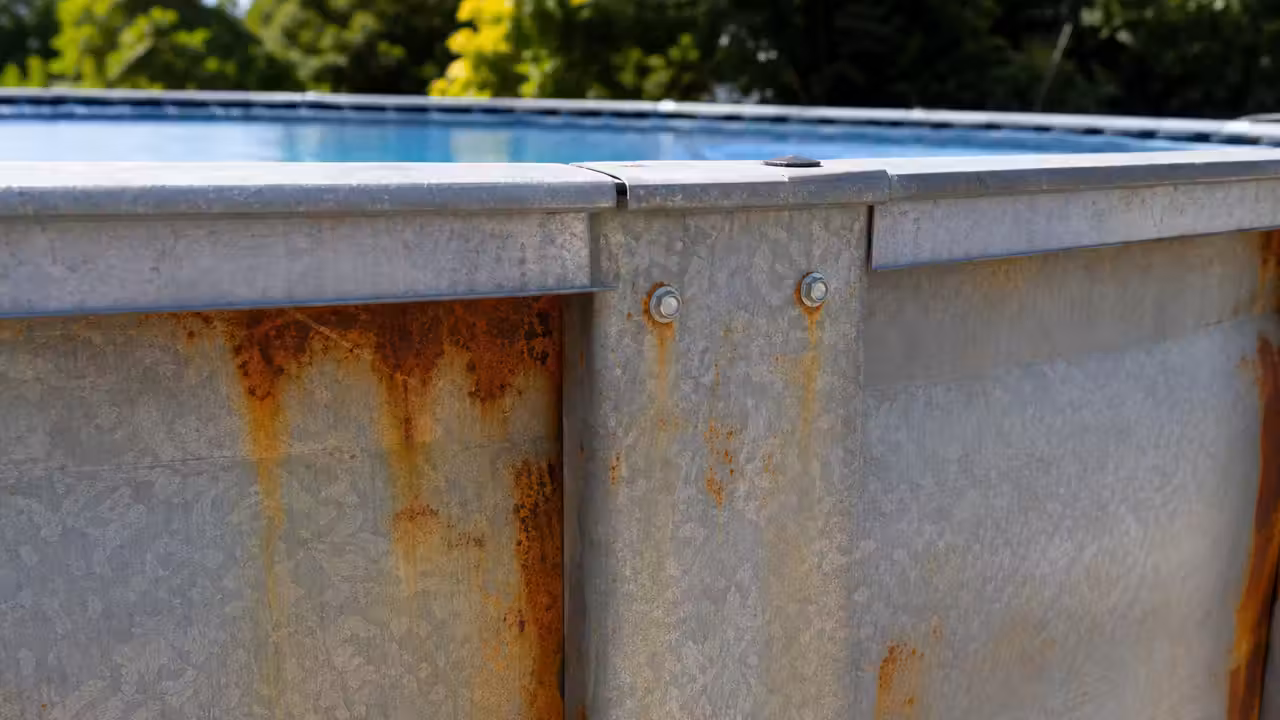 Panneau de structure métallique d'une piscine hors sol avec des taches de rouille près des vis d'assemblage