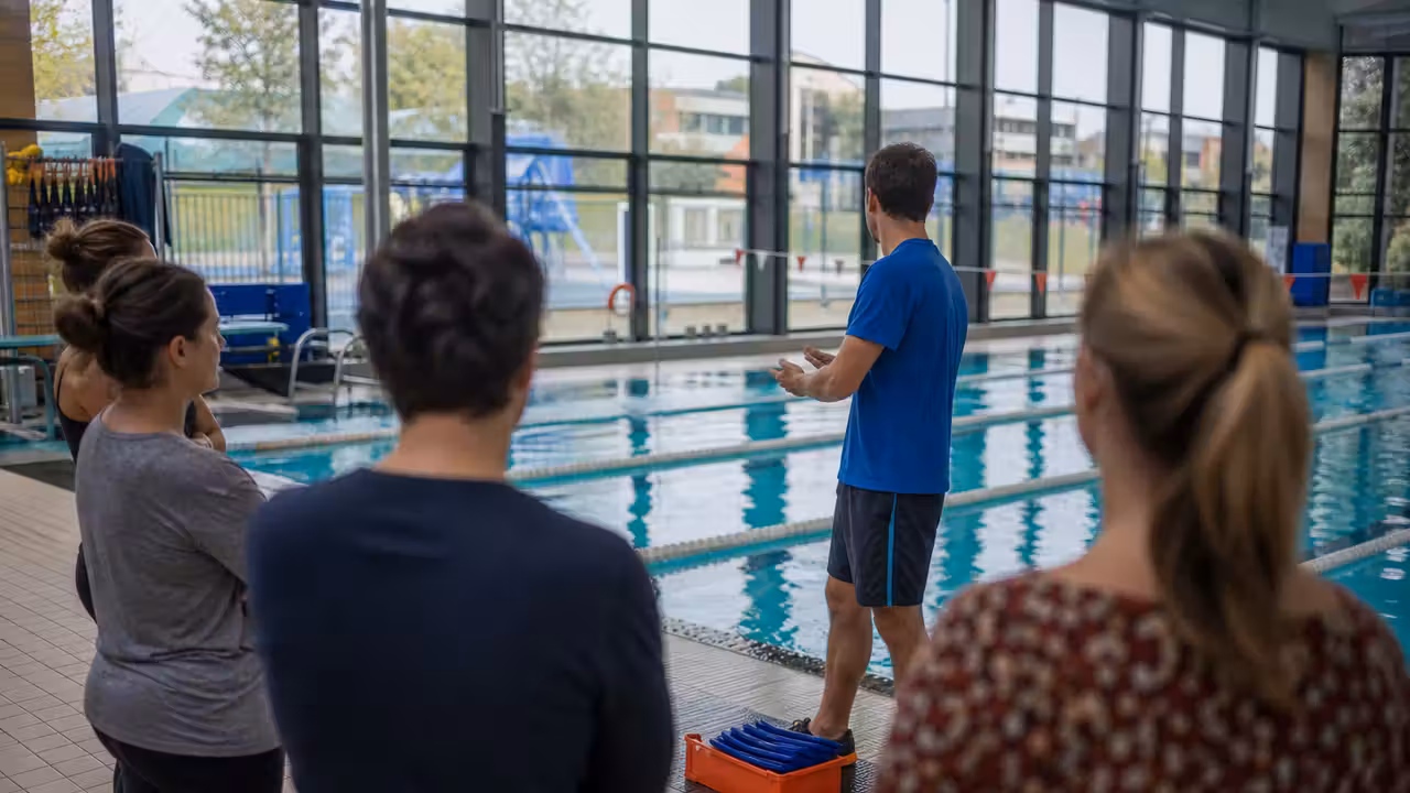 Parents bénévoles réunis au bord d’un bassin municipal avant une séance de natation scolaire encadrée