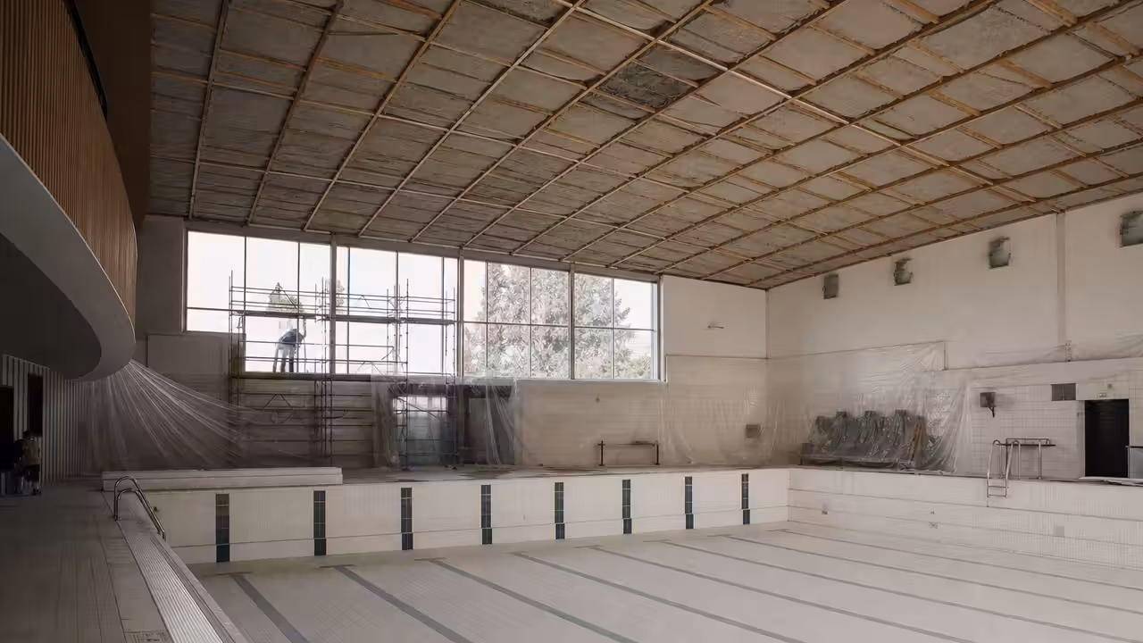 Bassin intérieur vide d’un centre aquatique pendant des travaux de rénovation thermique estivaux