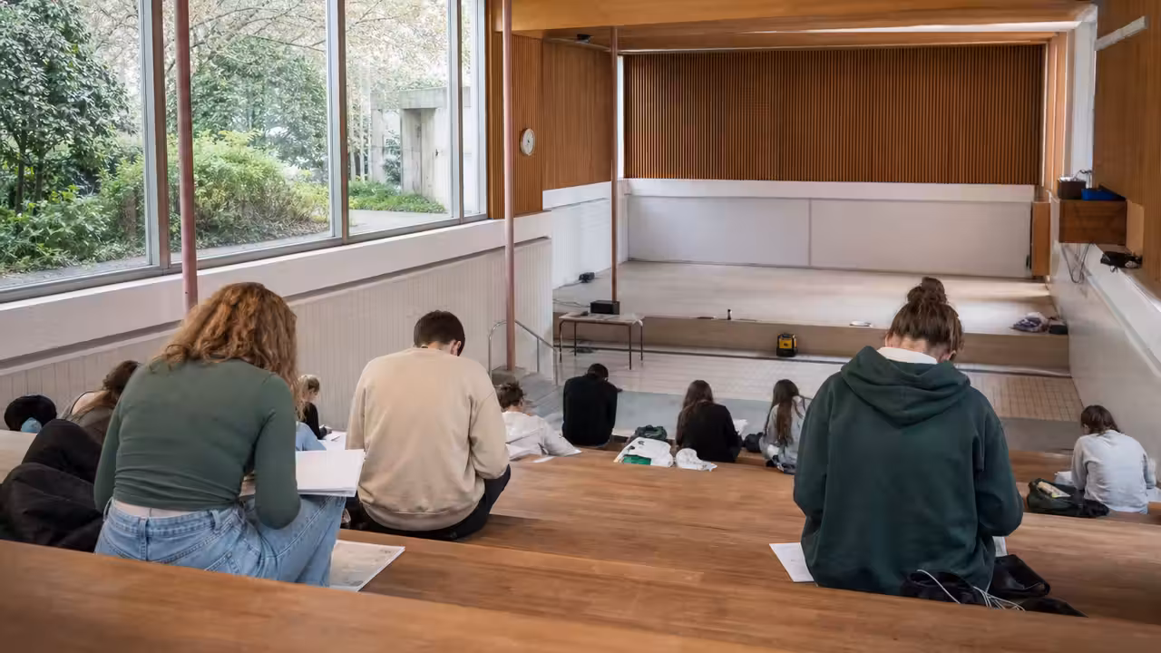 Ancienne piscine scolaire reconvertie en espace d’étude lumineux avec structure et mobilier en bois