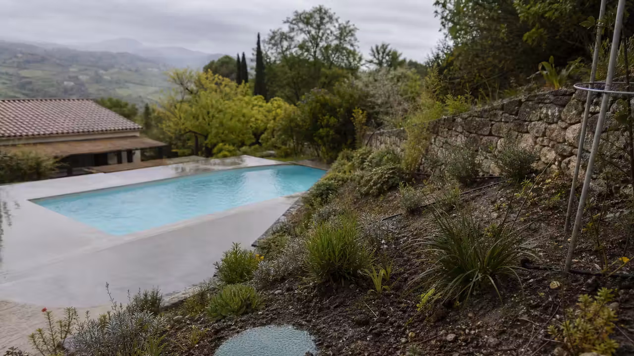 Terrain en pente près d’une piscine, avec évacuation d’eau contrôlée loin d’un réseau pluvial