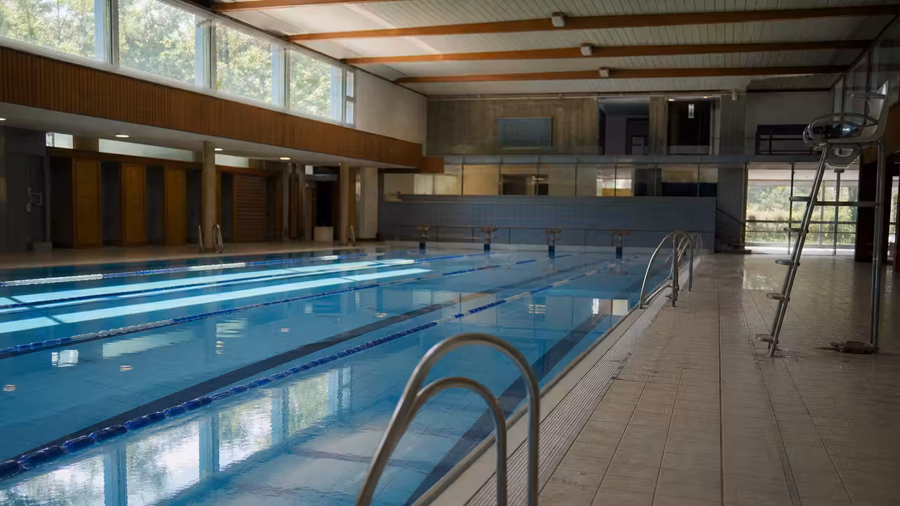 Hall et bassin d’une piscine publique avec couloirs de nage vides lors d’une ouverture réduite