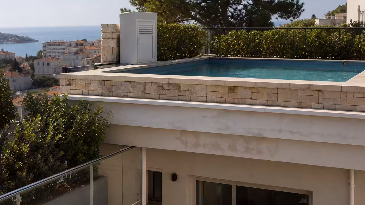 Terrasse d’immeuble avec bassin et traces d’humidité visibles au plafond du balcon situé à l’étage inférieur