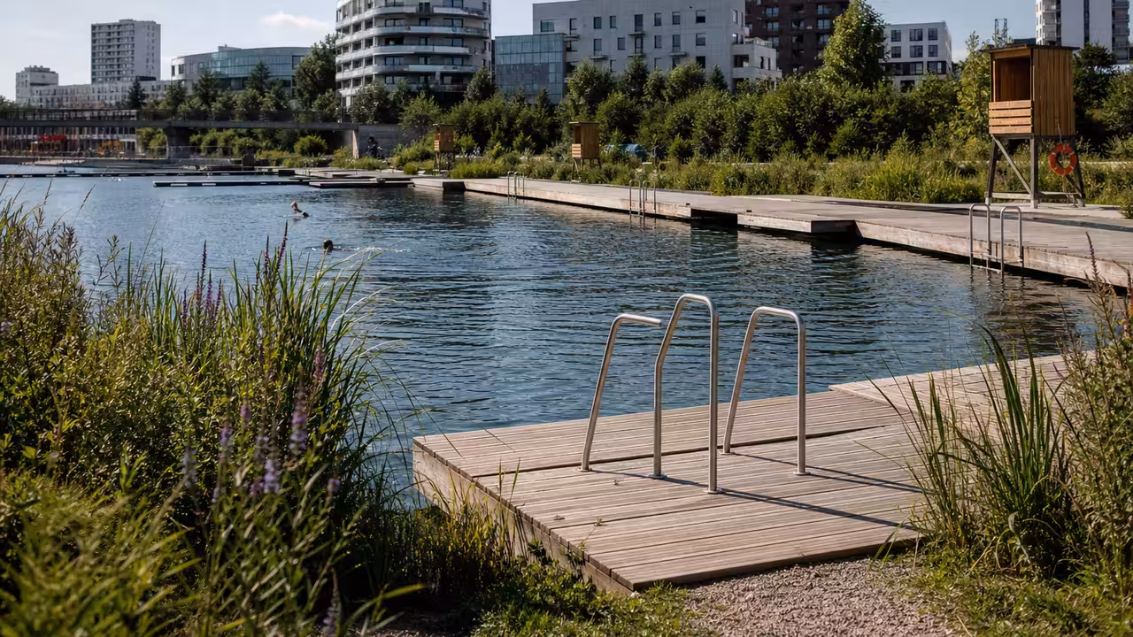 Bassins de baignade urbains au bord d’un plan d’eau, avec accès sécurisé et végétation riveraine