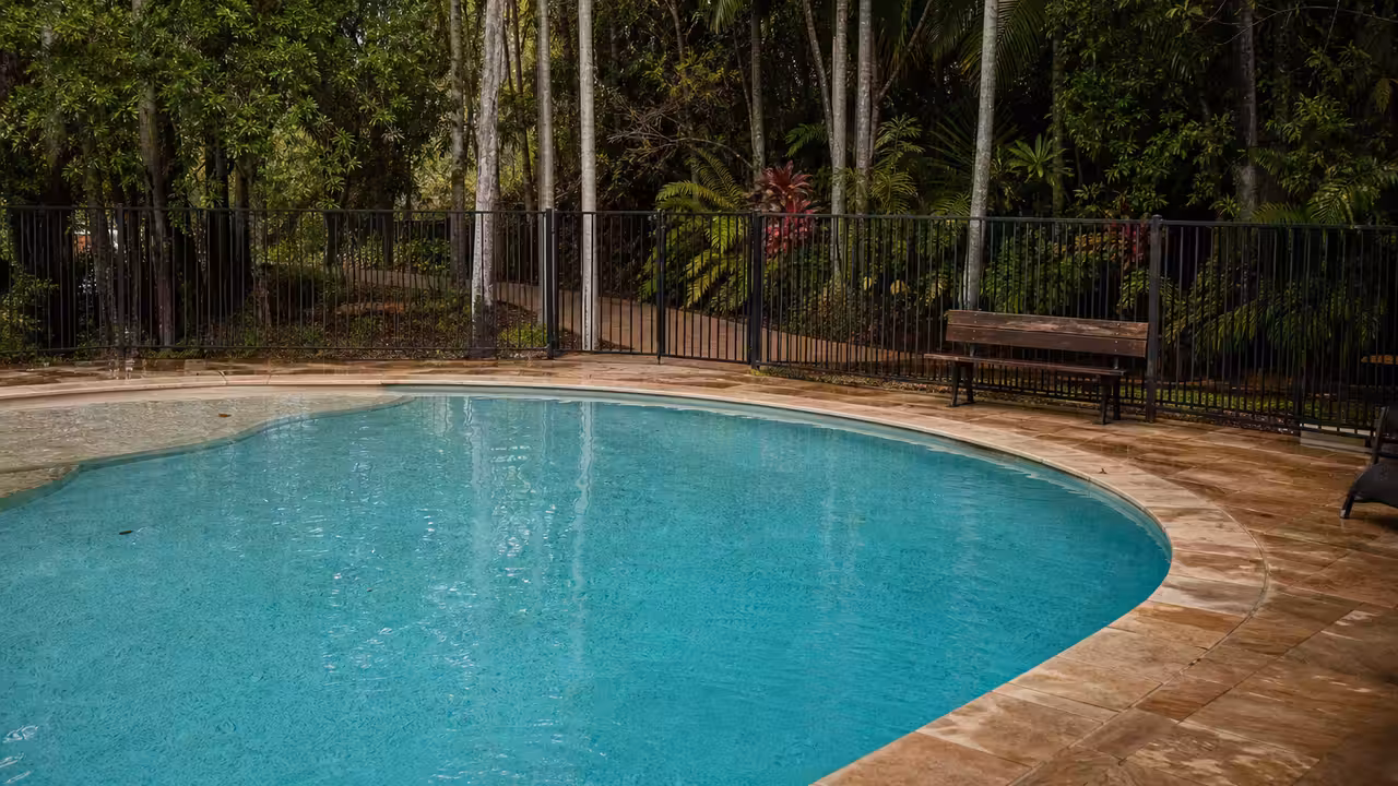 Piscine extérieure d’hôtel fermée par un ruban de sécurité dans un environnement tropical verdoyant