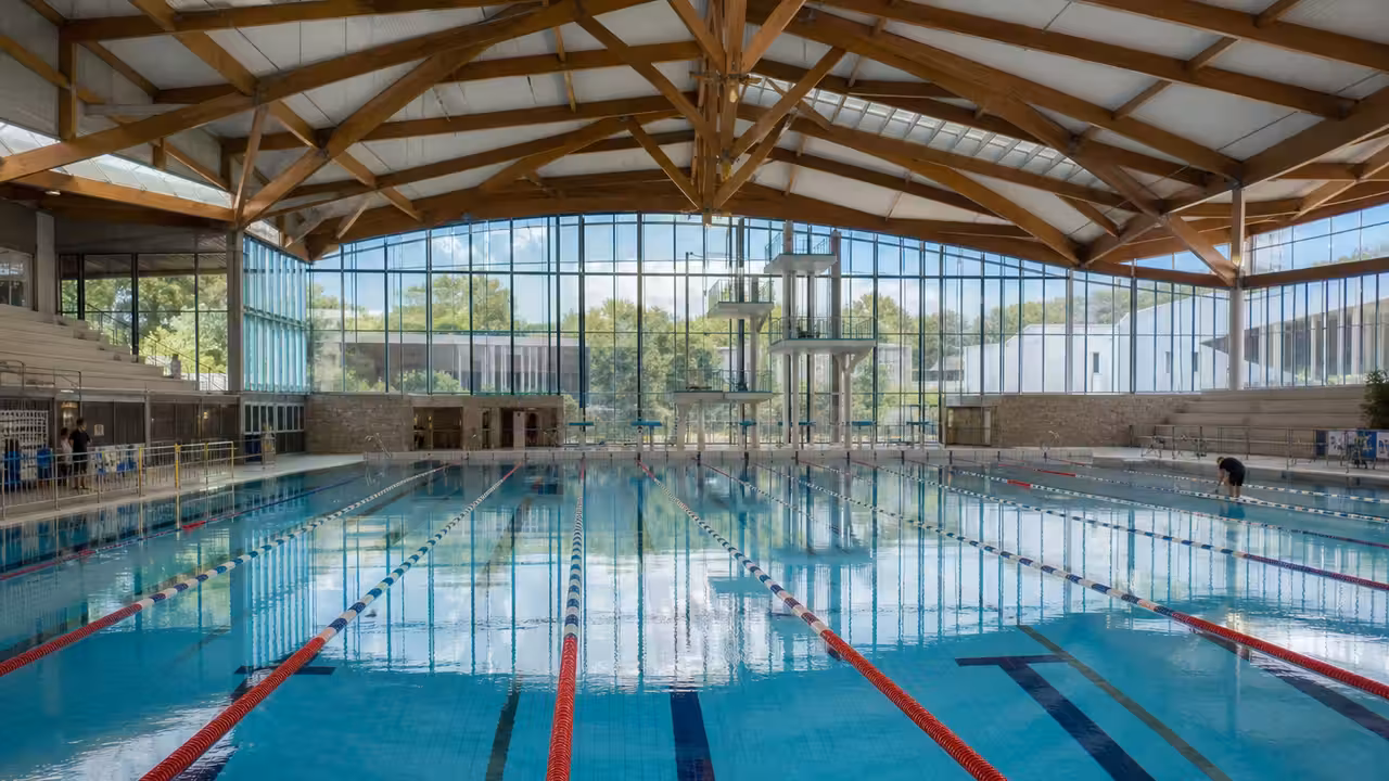Bassin sportif de 50 mètres dans un centre aquatique moderne, préparé pour une compétition de natation
