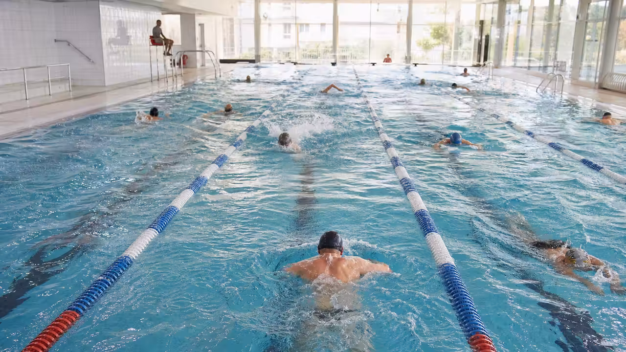Bassin couvert avec couloirs de nage occupés et espace de loisirs dans un centre aquatique