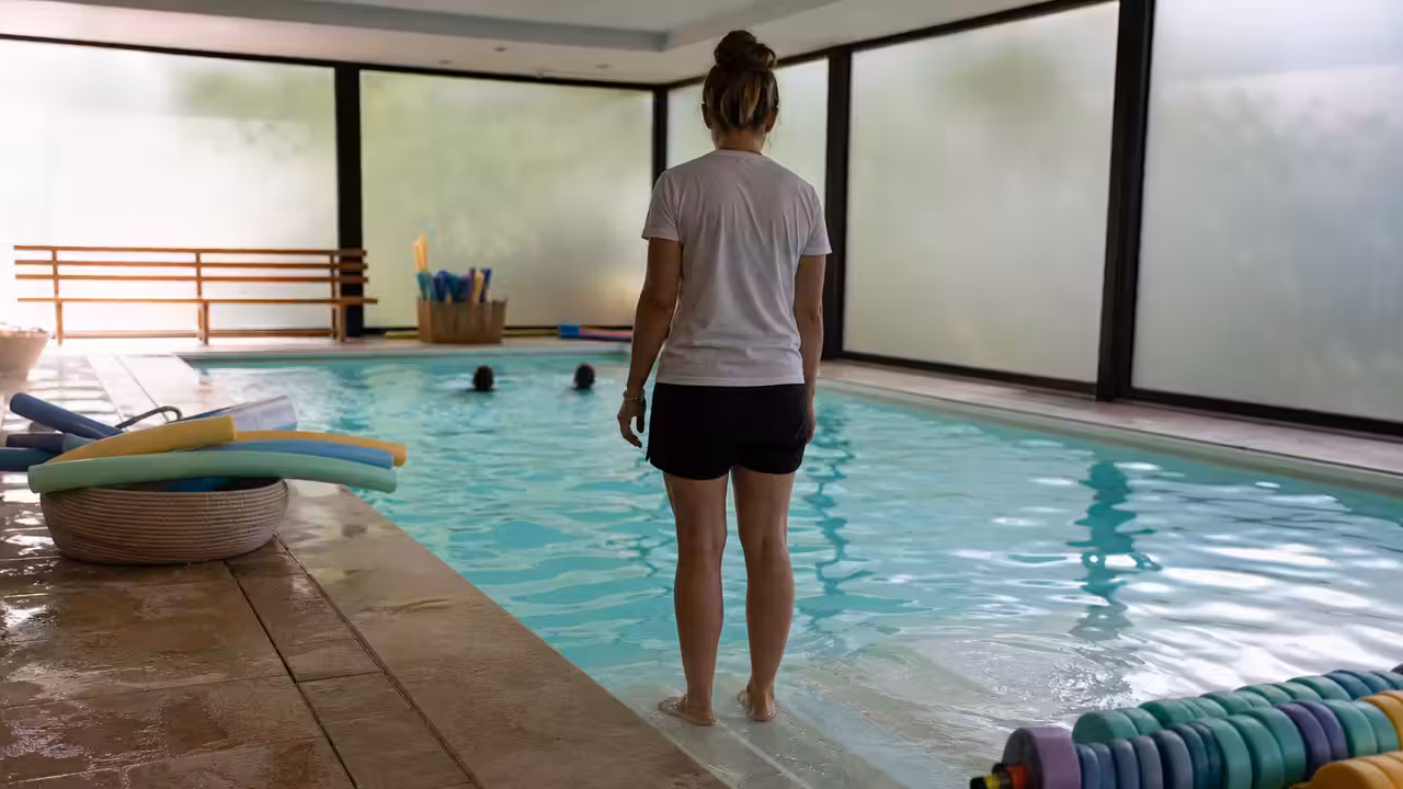 Bassin intérieur lumineux aménagé pour l’éveil aquatique, avec marches visibles et plage antidérapante