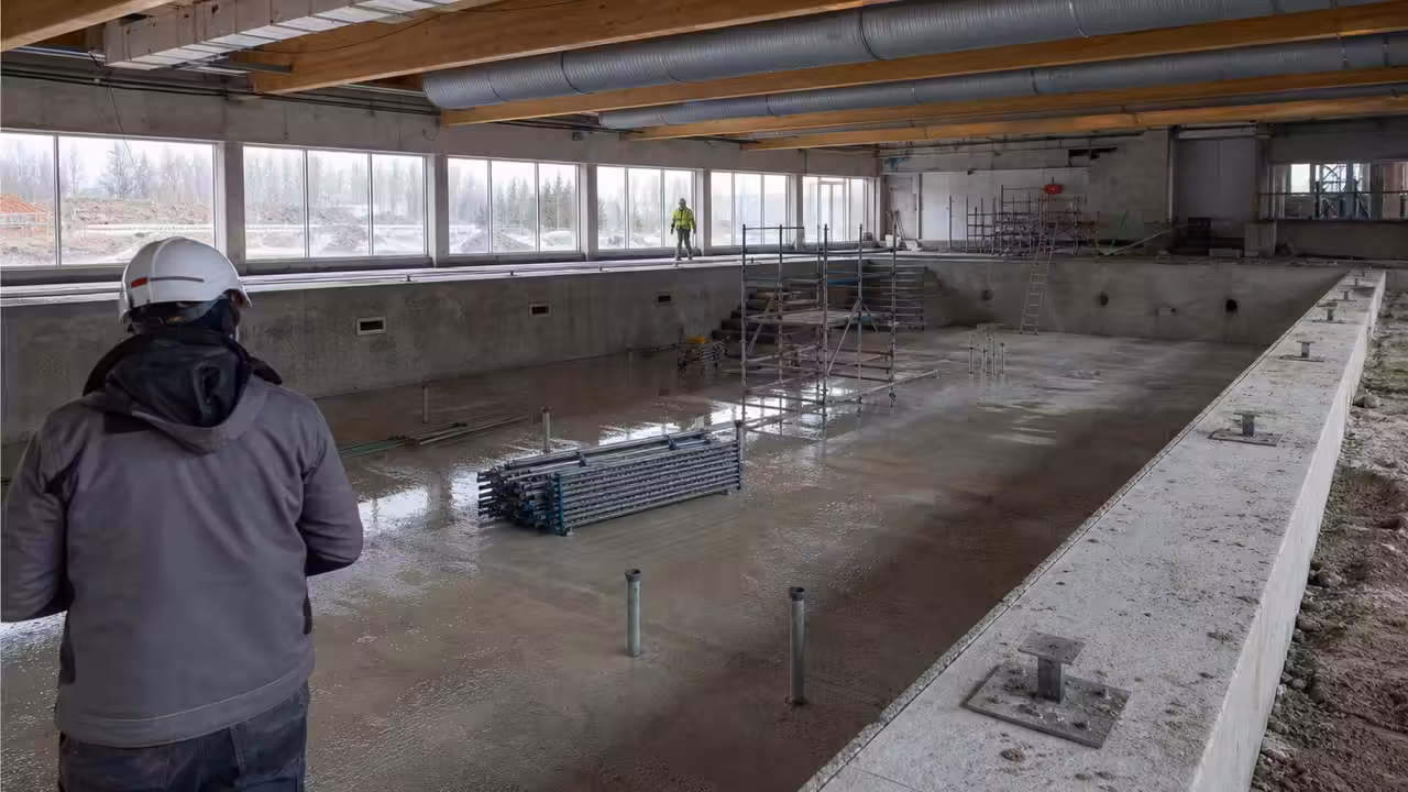 Vue d’ensemble d’un chantier de piscine publique moderne avec bassin en construction et structures techniques