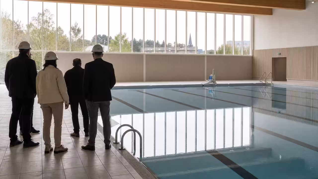 Bassin de nage couvert dans un centre aquatique municipal moderne, lumineux et accessible