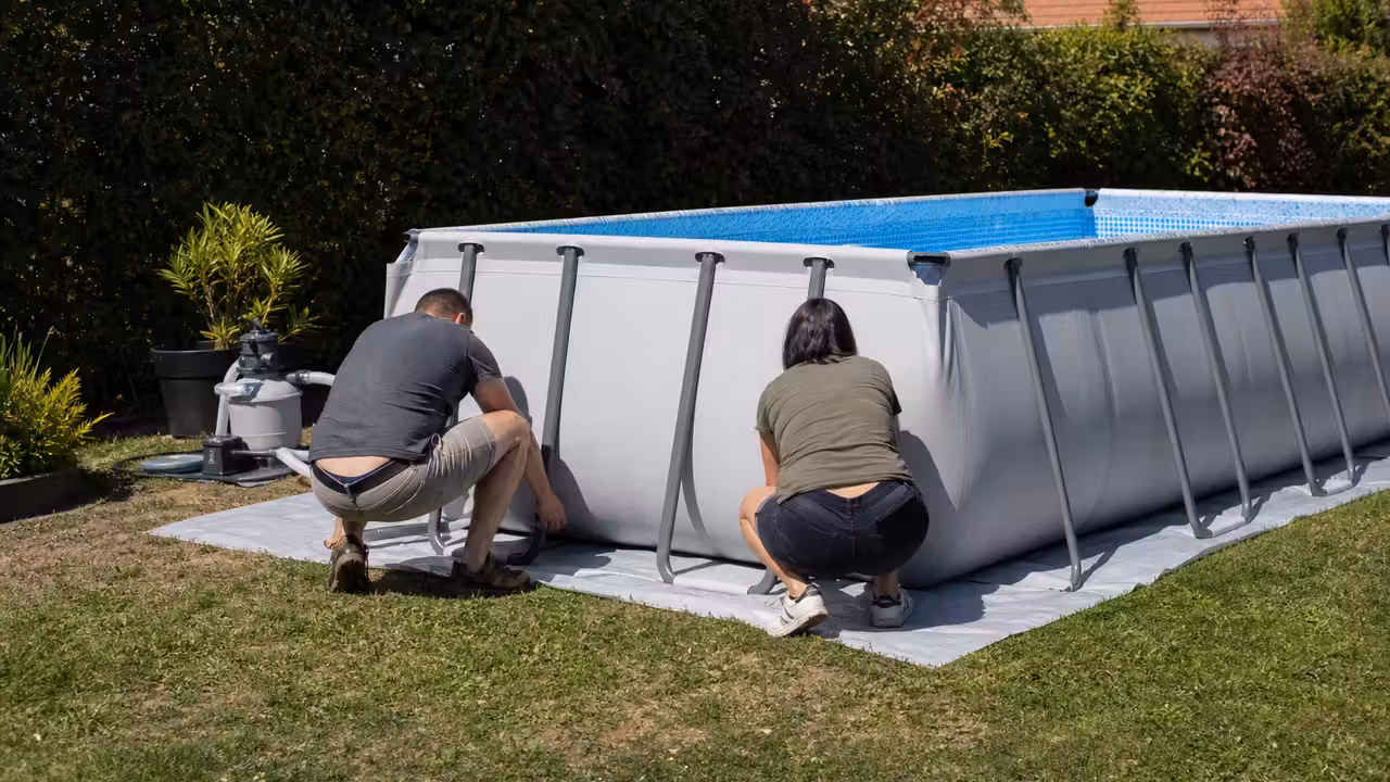 Piscine hors-sol tubulaire installée sur un jardin plat avec bâche de sol et filtration à proximité