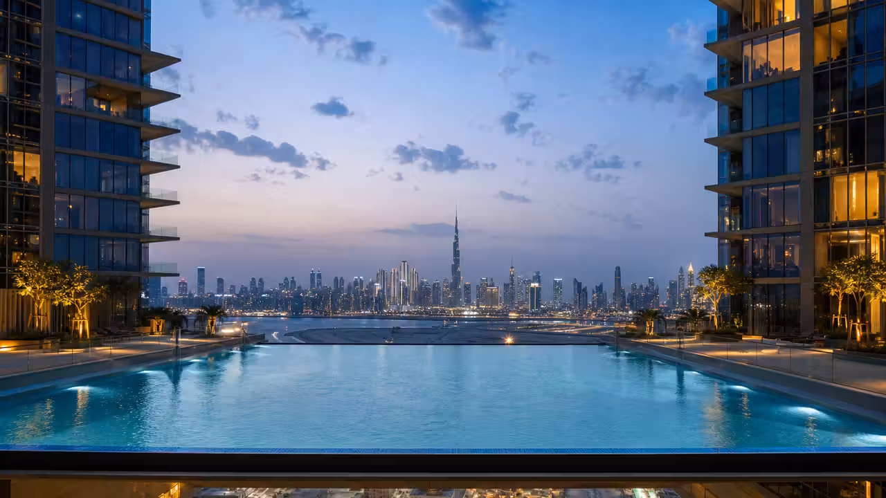 Deux tours contemporaines reliées en hauteur par une piscine suspendue éclairée au-dessus de Dubaï.