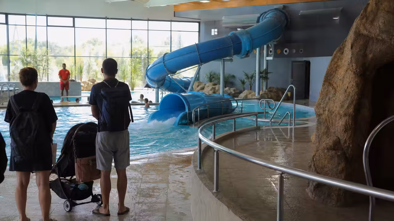 Toboggan aquatique intérieur et bassin de réception surveillé dans un centre aquatique municipal français