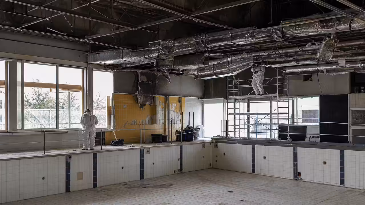Hall de piscine municipale en rénovation, avec bassins vides et réseaux de ventilation en cours d’installation