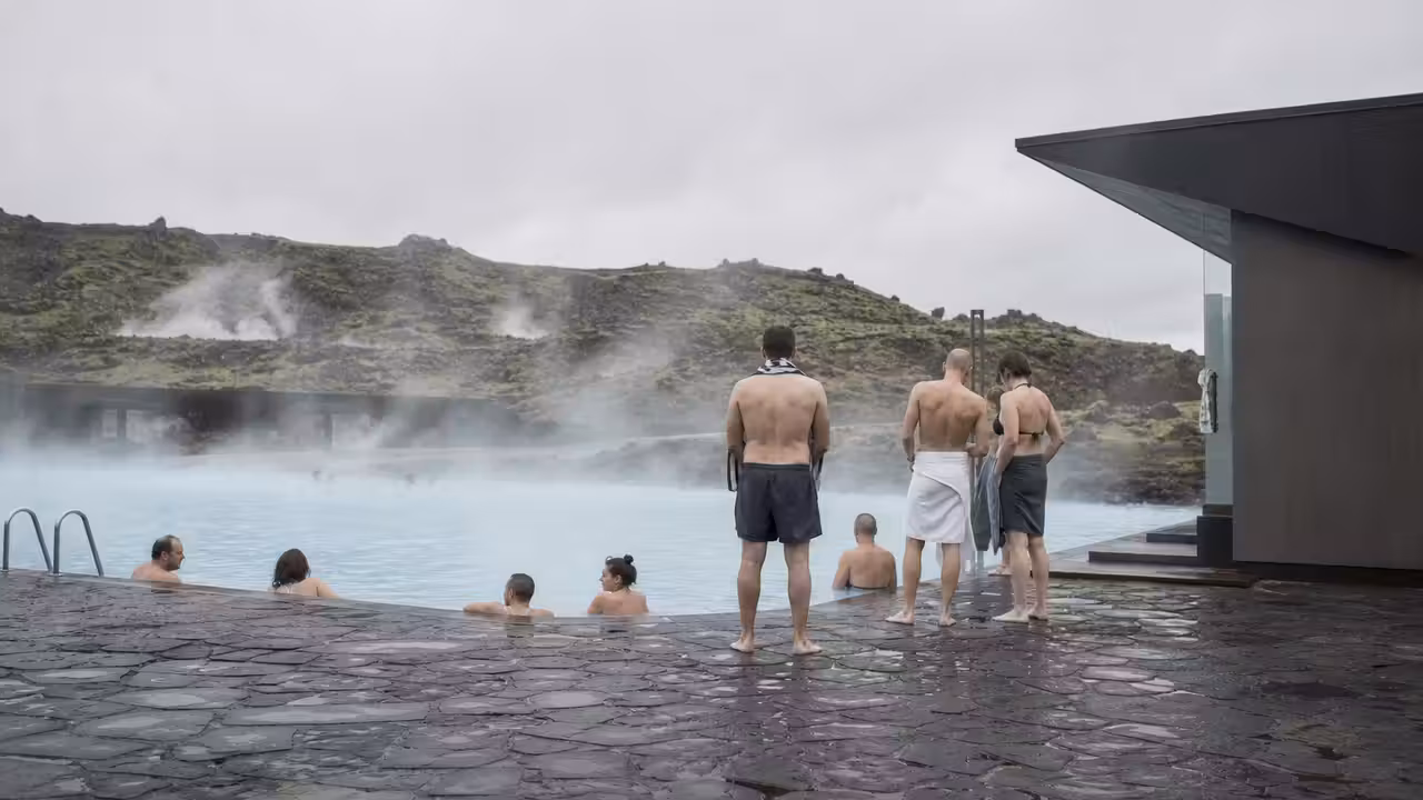 Bassin extérieur chauffé en Islande, nageurs au loin et bains chauds dans une lumière froide
