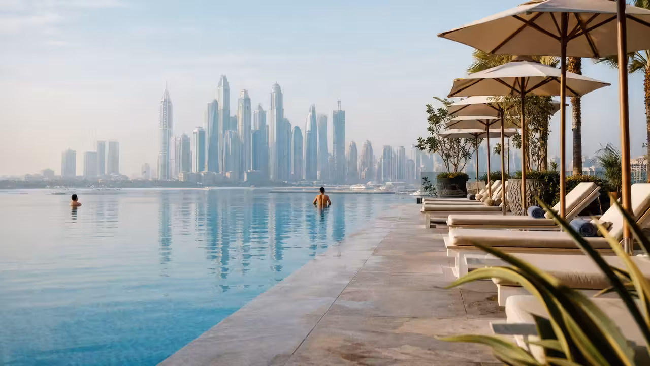 Piscine à débordement d’un hôtel à Dubaï, transats ombragés et skyline urbaine à l’arrière-plan